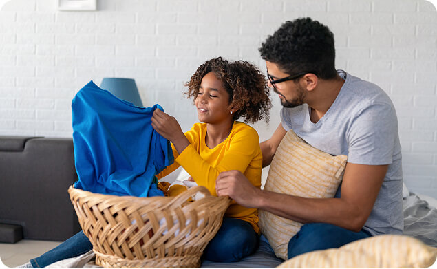 A man and child folding laundry